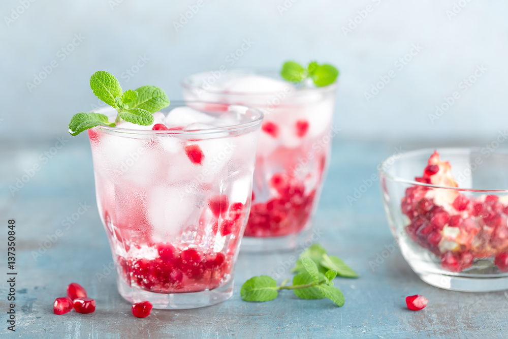 Infused water made of fresh pomegranate and mineral water with ice, cold refreshing and detox drink Infused water made of fresh pomegranate and mineral water with ice, cold refreshing and detox drink