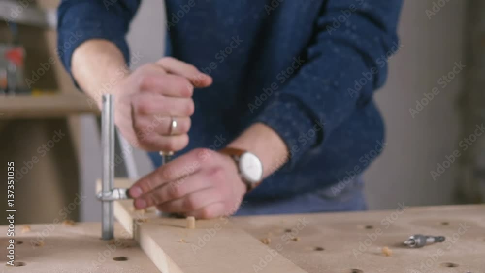 Young man working as carpenter and measuring board Young man working as carpenter and measuring board