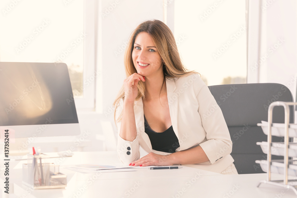 Young self-confident businesswoman in her office Young self-confident businesswoman in her office