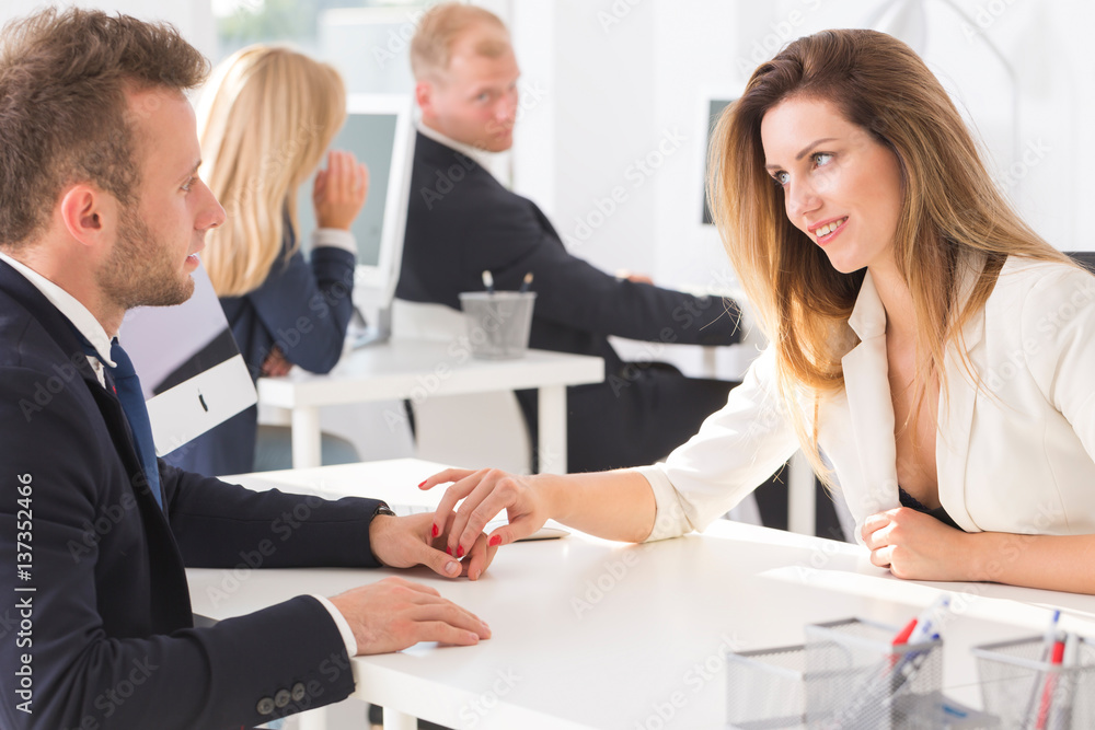 Fototapeta premium Two employees holding hands in the office