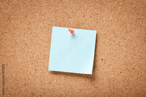 Blue blank sticky note on corkboard © ffphoto