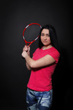 Young woman with a tennis racket on a black background
