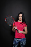 Young woman with a tennis racket on a black background