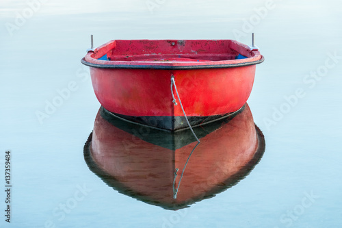 Obraz na plátně red wooden fishing boat on a background of water