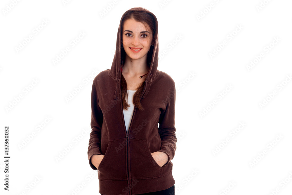 Cutie young brunette student in brown sport clothes with hood posing and smiling isolated on white background Cutie young brunette student in brown sport clothes with hood posing and smiling isolated on white background