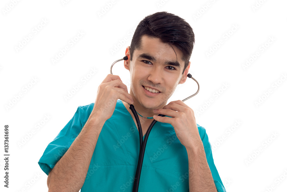 portrait of cheerful young brunette man doctor in blue uniform with stethoscope posing isolated on white background portrait of cheerful young brunette man doctor in blue uniform with stethoscope posing isolated on white background