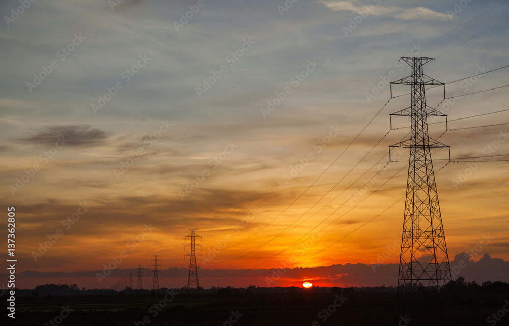 Sunset against high electric voltage pole landscape