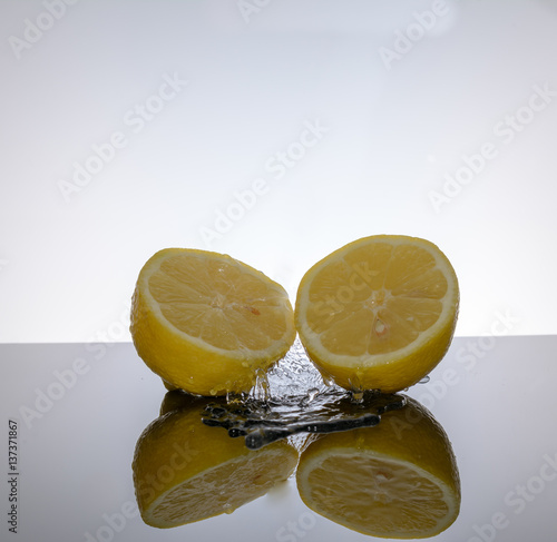 Zitrone - Limette mit Wasser vor weissem Hintergrund