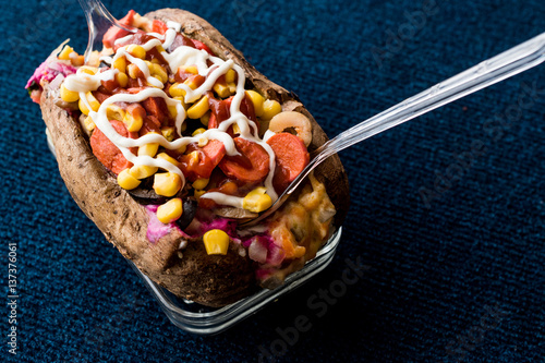 Kumpir / Turkish Baked potato with cheese, corn, sausage, ketchup and mayonnaise. photo