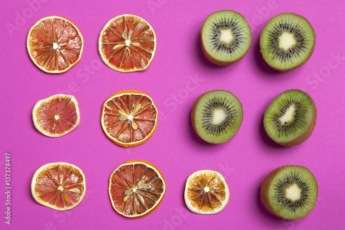 dried orange and lemon slice on a burgundy background as an art work that can be used for decoration © elenarostunova