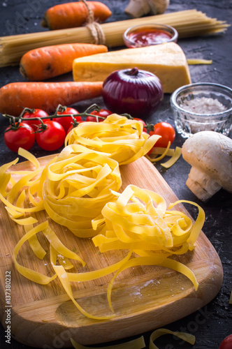 Raw tagliatelle on a dark background