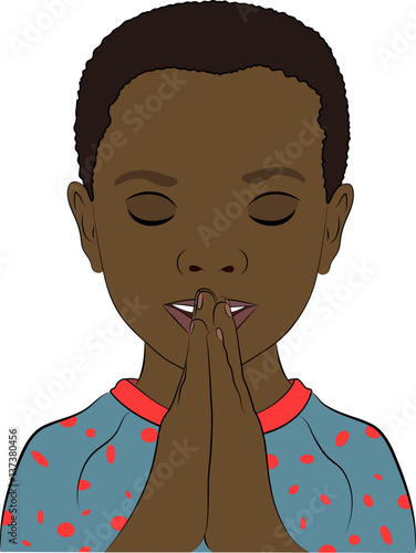 A young african boy wearing pajamas with his hands together in prayer.