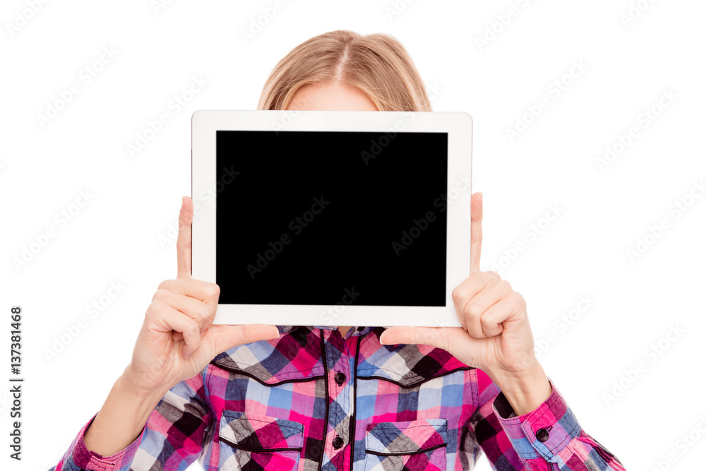 Shy woman hiding face behind black screen of tablet