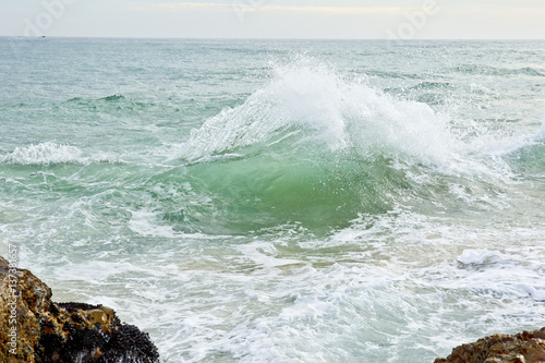 Canvas-taulu sea wave off a rocky coast
