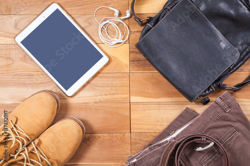 Outfits and accessories of traveler on wooden background