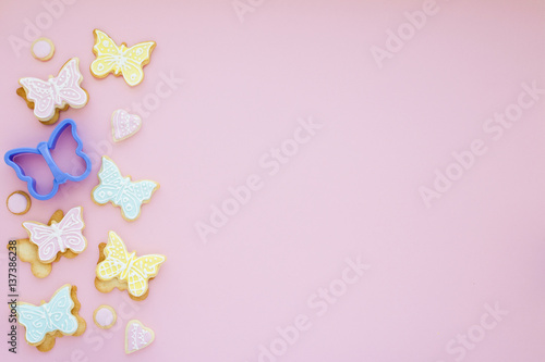 Homemade biscuits with ornate and form of butterfy on pink background © Olga Zarytska
