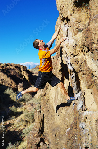 man rock climbing a boulder