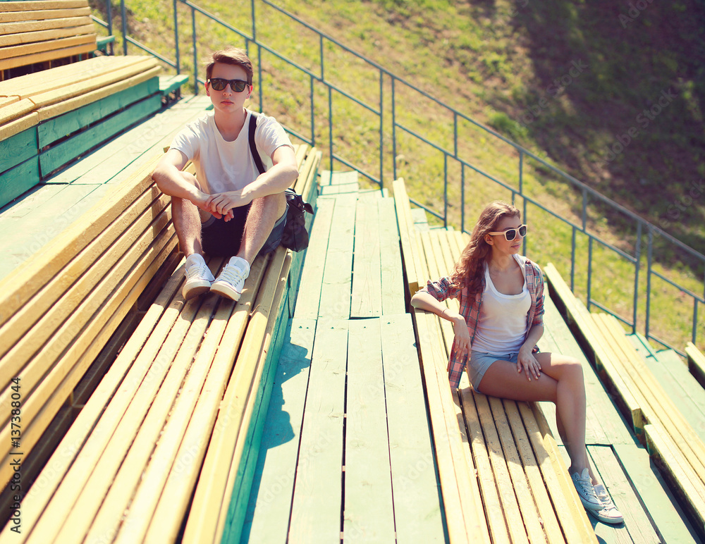 Young couple resting on the bench, youth, teenagers, fashion - concept