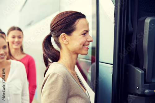 group of happy passengers boarding travel bus