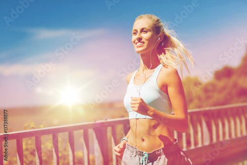 Fototapeta Naklejka Na Ścianę i Meble -  smiling young woman running outdoors