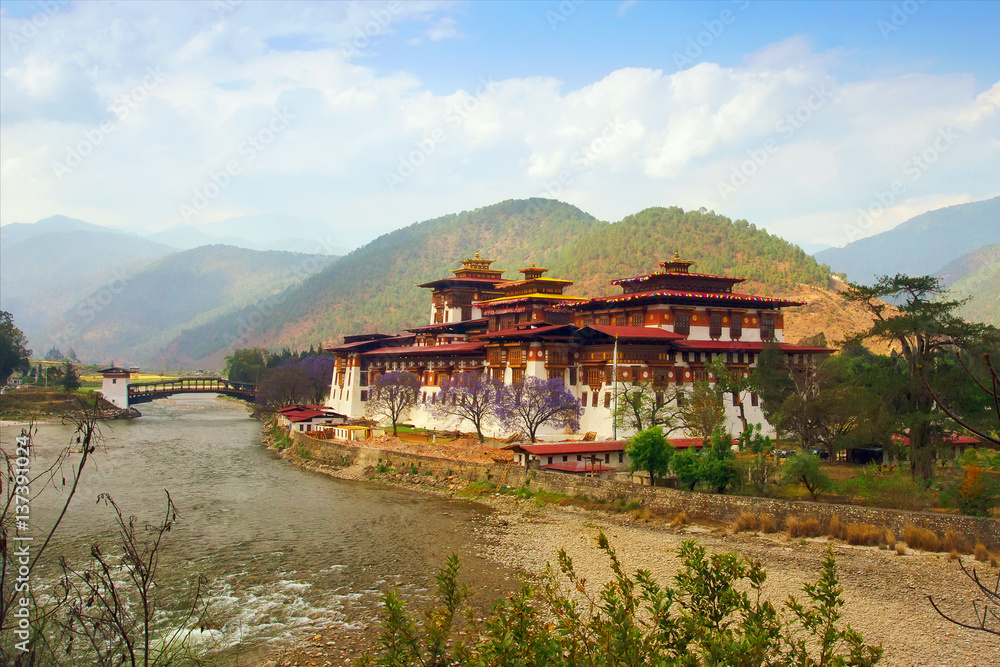 Bhutan landscape. Punakha Dzong, monastery and medieval castle, in the river bank, one of the largest monasteries in Asia with beautiful green hills background, Himalaya, Bhutan, Asia