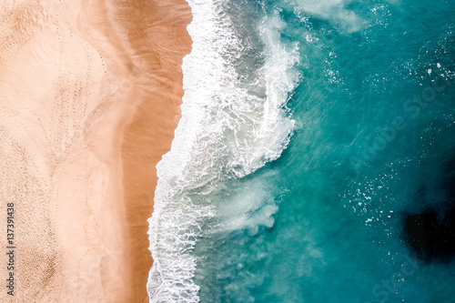 Teal Wave crashes on amber shore photo