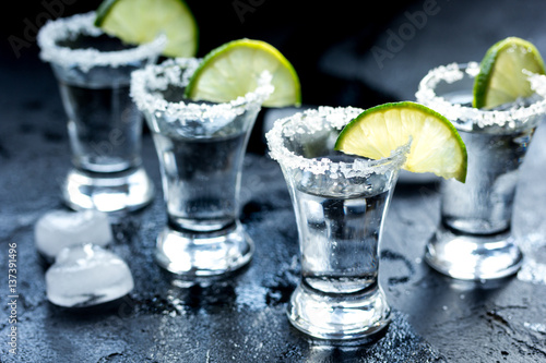 Alcohol shots with lime and salt on black background