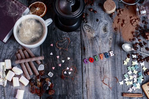 Abstract background with sweets and a cup of black coffee on a gray wooden surface