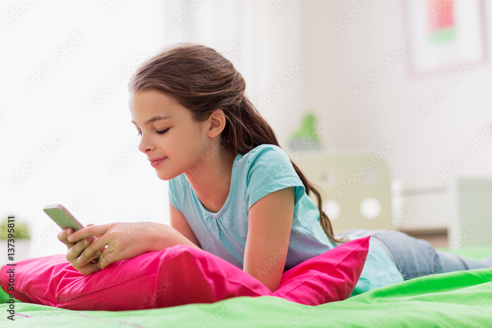 smiling girl texting on smartphone at home smiling girl texting on smartphone at home