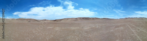 Panoramic view to desert and blue cloudy sky above it