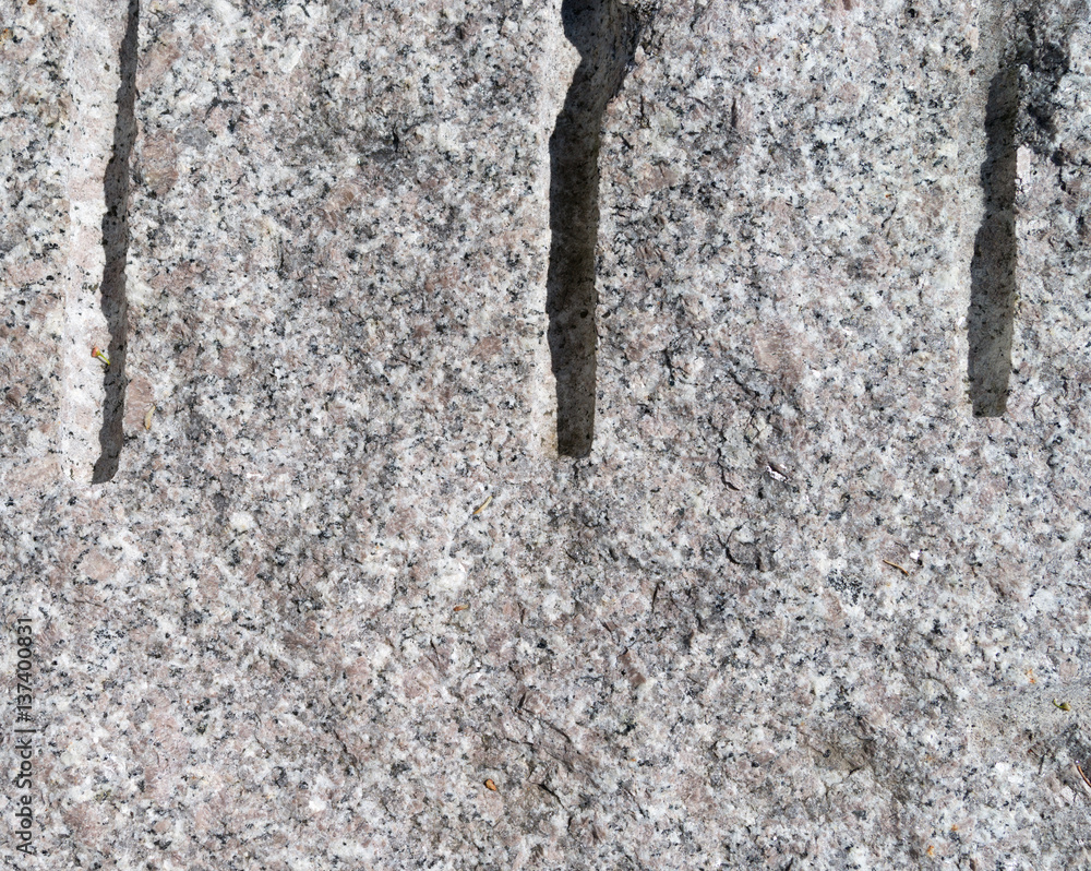 Drill holes in a cut granite block close view. foto de Stock Adobe Stock
