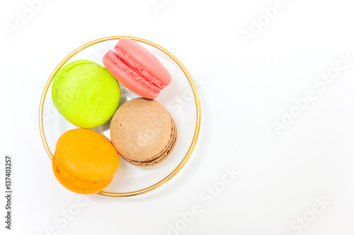 Sweet and colourful french macaroons or macaron in a glass bowl on white background, Top view with copy space for your text.