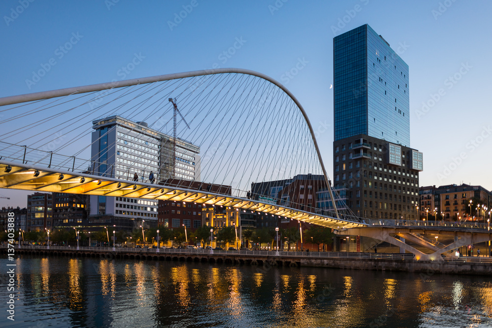 Fototapeta premium View to the Plaza de la Convivencia with the famous bridge Puente Zubizuri, The white bridge, also named Campo Volantin Bridge, is a tied arch footbridge across the Nervion River in Bilbao, Spain