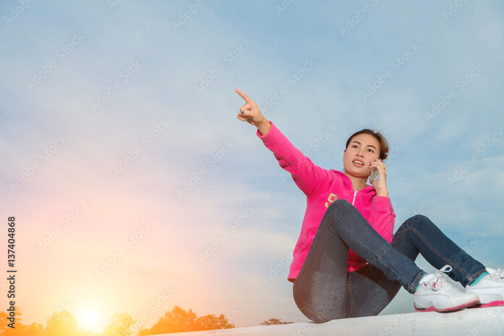 young woman using a smart phone at sunset. young woman using a smart phone at sunset.