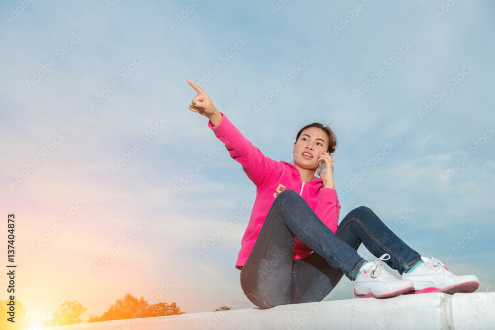 young woman using a smart phone at sunset. young woman using a smart phone at sunset.