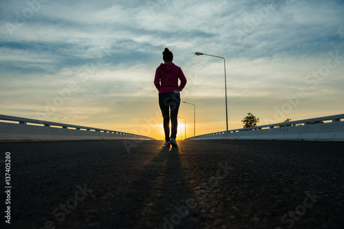 silhouette woman walking on the street at sunset.
