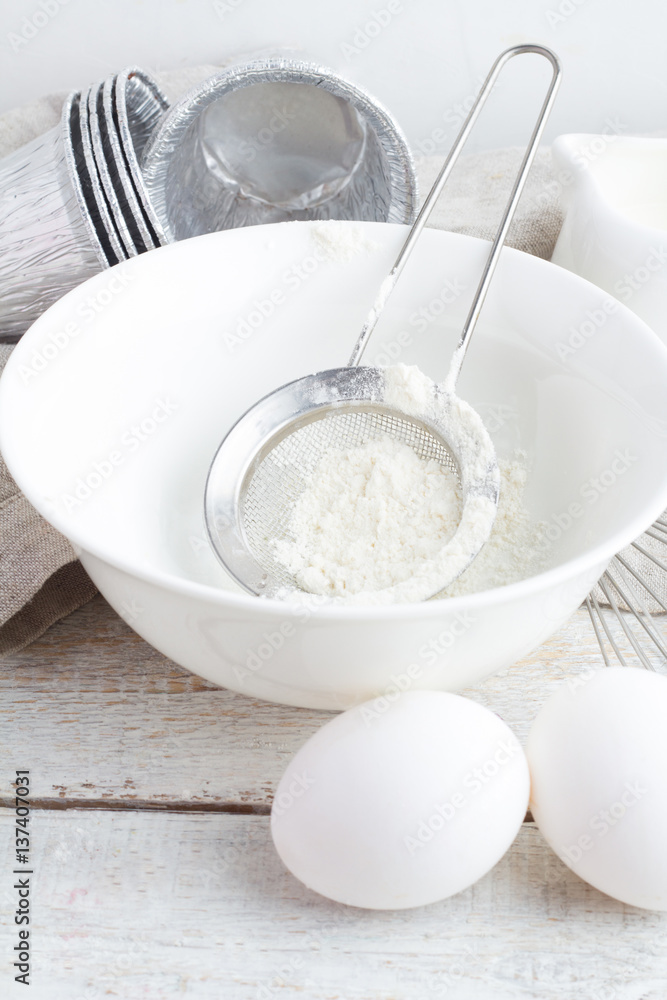 bowl with flour, eggs and milk on a white background closeup bowl with flour, eggs and milk on a white background closeup