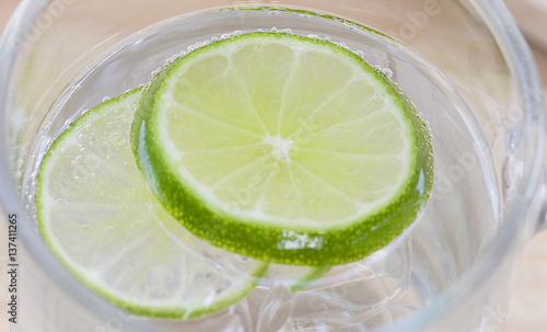 closeup lime in glass of soda, cold refreshing soft drink © Pongsak