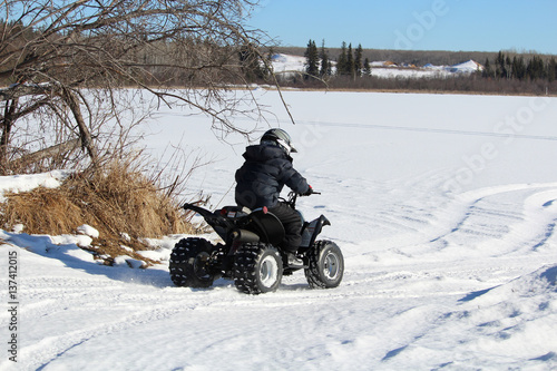 Child Driving His Quad Onto a Frozen Lake