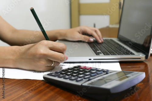 woman working with calculator, business document and laptop computer notebook,business  finance, selective focus