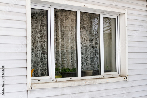 large plastic window on the wall of siding