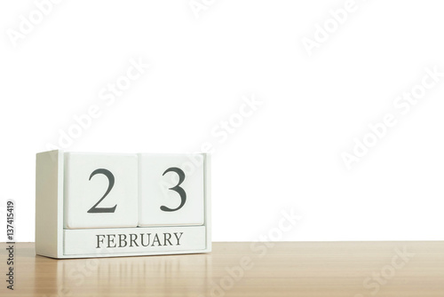 Closeup surface white wooden calendar with black 23 february word on blurred brown wood desk isolated on white background with copy space , selective focus at the calendar