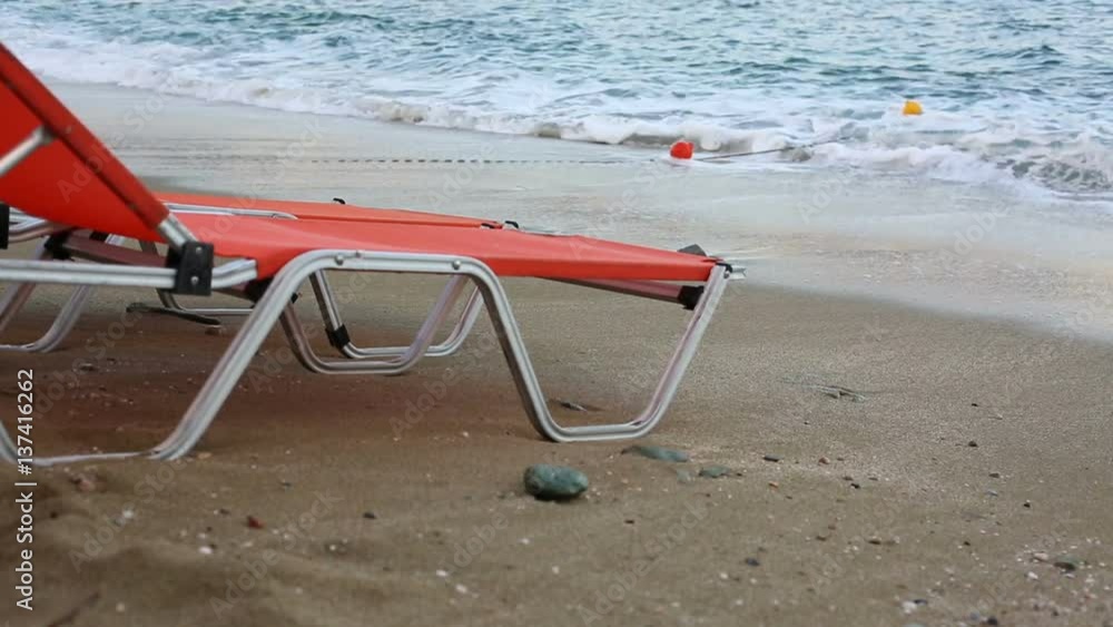 Empty sunbeds standing on a beach by a blue sea Empty sunbeds standing on a beach by a blue sea