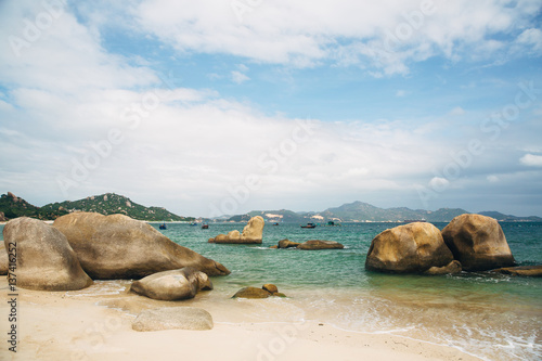 Beautiful landscape with view of ocean, perfect beach, big stones, trees, azure water. Background image. Concept travel