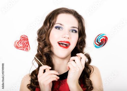 portrait of young beautiful woman with dental braces holding sugarplum photo