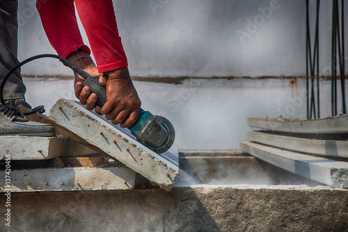 Builder worker with grinder machine cutting concreate floor at construction site