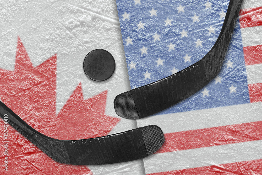 Fototapeta premium Canadian and American flags, and two hockey sticks hockey