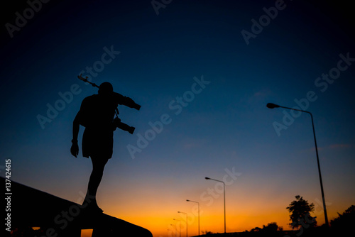 silhouette of a photographer who shoots a sunset.