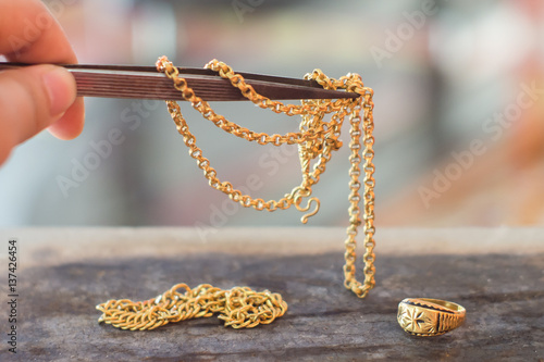 Old gold and tweezers on ti...