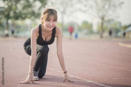 Fit and confident woman in starting position ready for running with vintage color